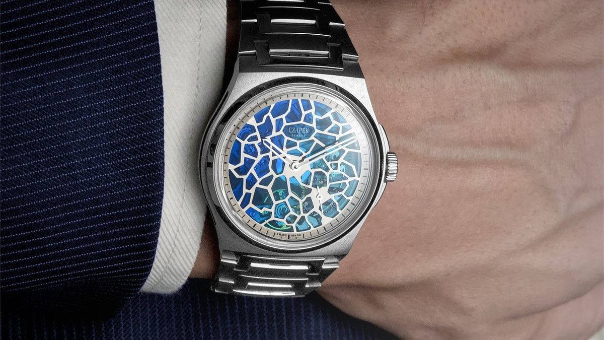 Czapek Antarctique Plique-à-Jour Polar Blue worn on the wrist under a navy pinstripe suit sleeve