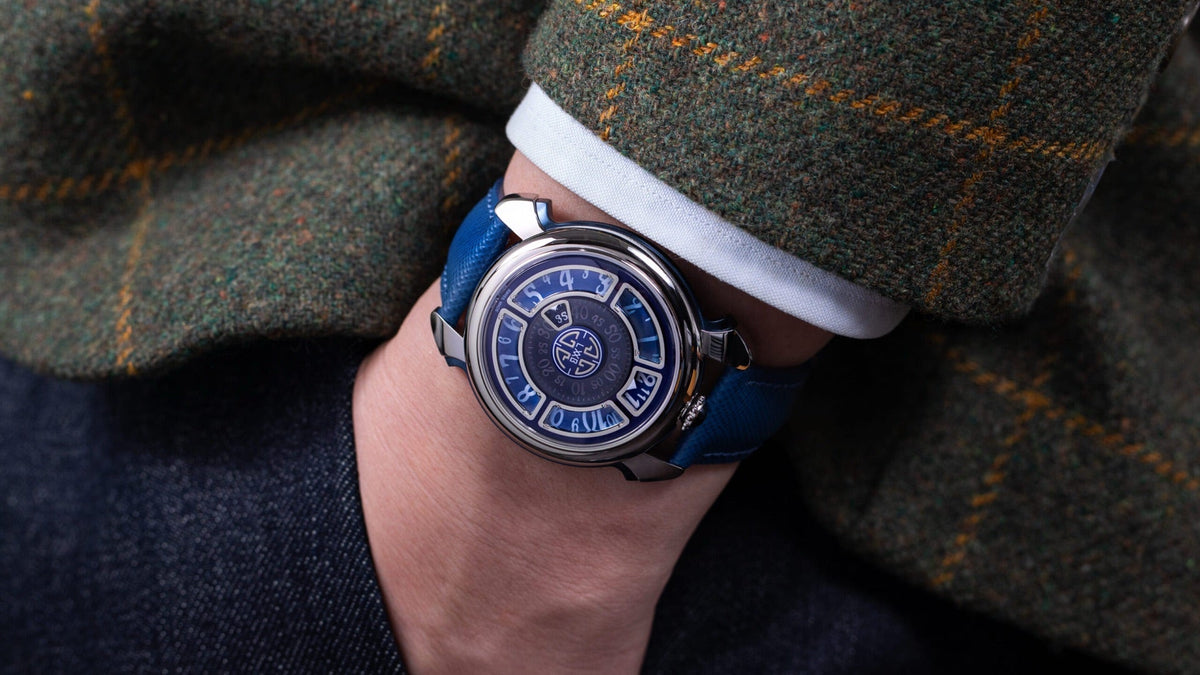 Gagà Laboratorio Labormatic Luce worn on the wrist under a tweed jacket sleeve, blue dial in four sectors
