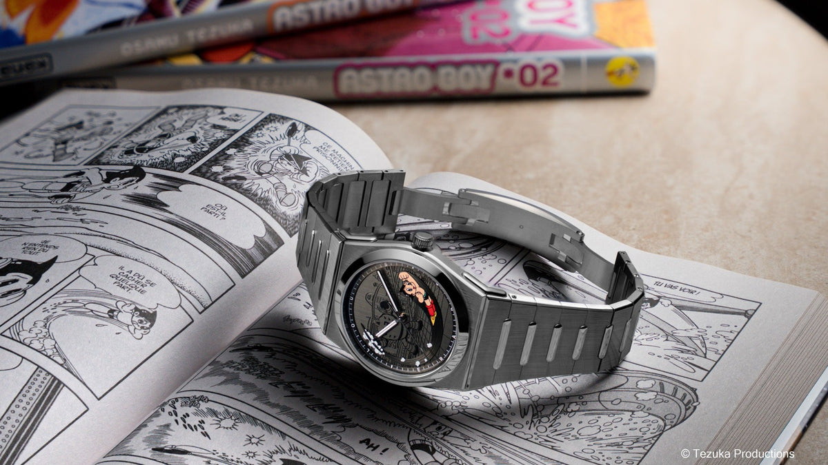 Louis Erard x Astro Boy 2340 resting on an open Astro Boy manga, Astro Boy manga volumes behind