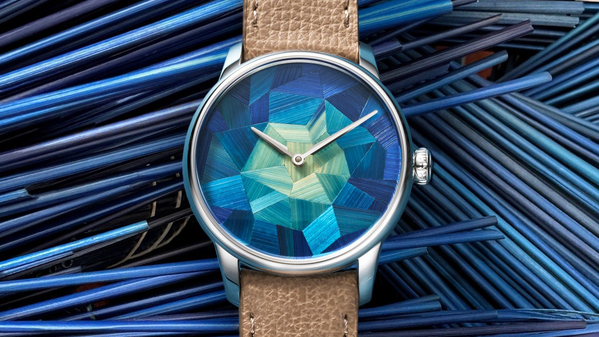 Louis Erard Marqueterie de Paille lying on a bed of blue-dyed straw, dial and beige leather strap visible