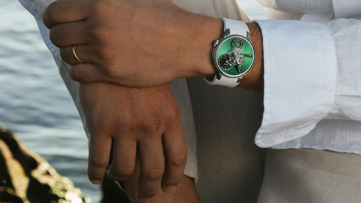 MB&F Legacy Machine 101 EVO, peacock green dial, worn on the wrist beside the sea