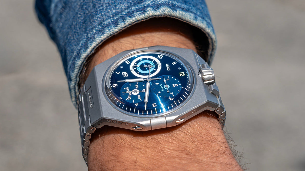 URWERK UR-10 SpaceMeter Blue worn on the wrist under a denim sleeve, close view