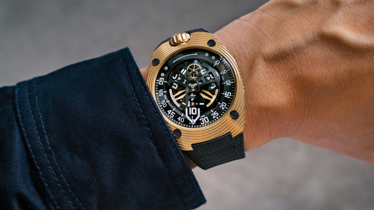URWERK UR-150 Golden Scorpion worn on the wrist, in yellow gold with a black rubber strap